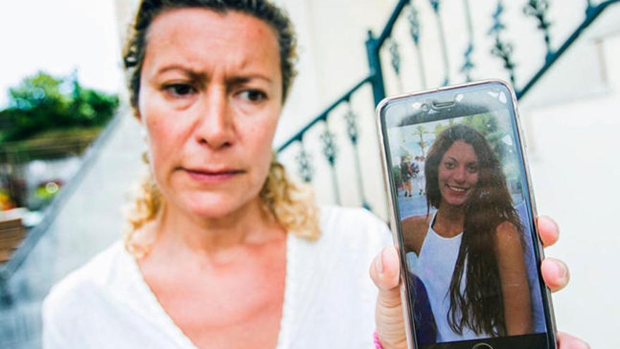 La madre de Diana sostiene un teléfono con una foto de la joven. // I.A.