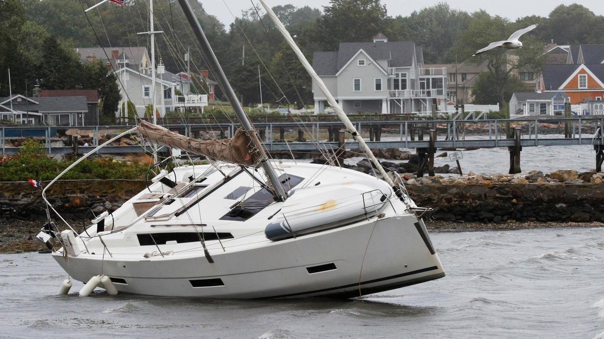 Un velero que se soltó de sus amarras es arrastrado a la costa durante la tormenta tropical Henri en Jamestown.