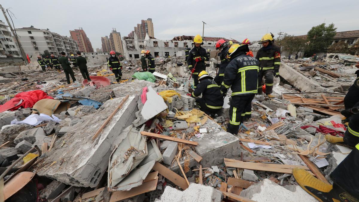 Equipos de rescate inspeccionan los escombros tras la explosión de una fábrica en China