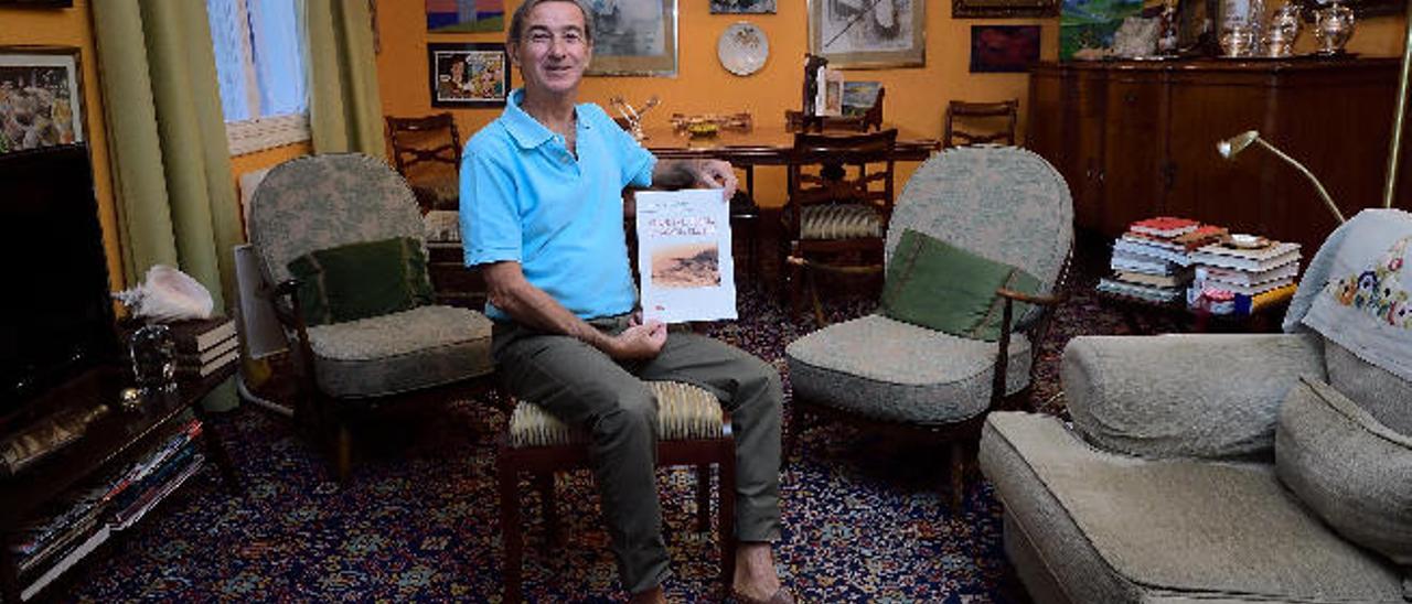 Javier Campos, en su casa de Tafira, sujetando un borrador de su libro.