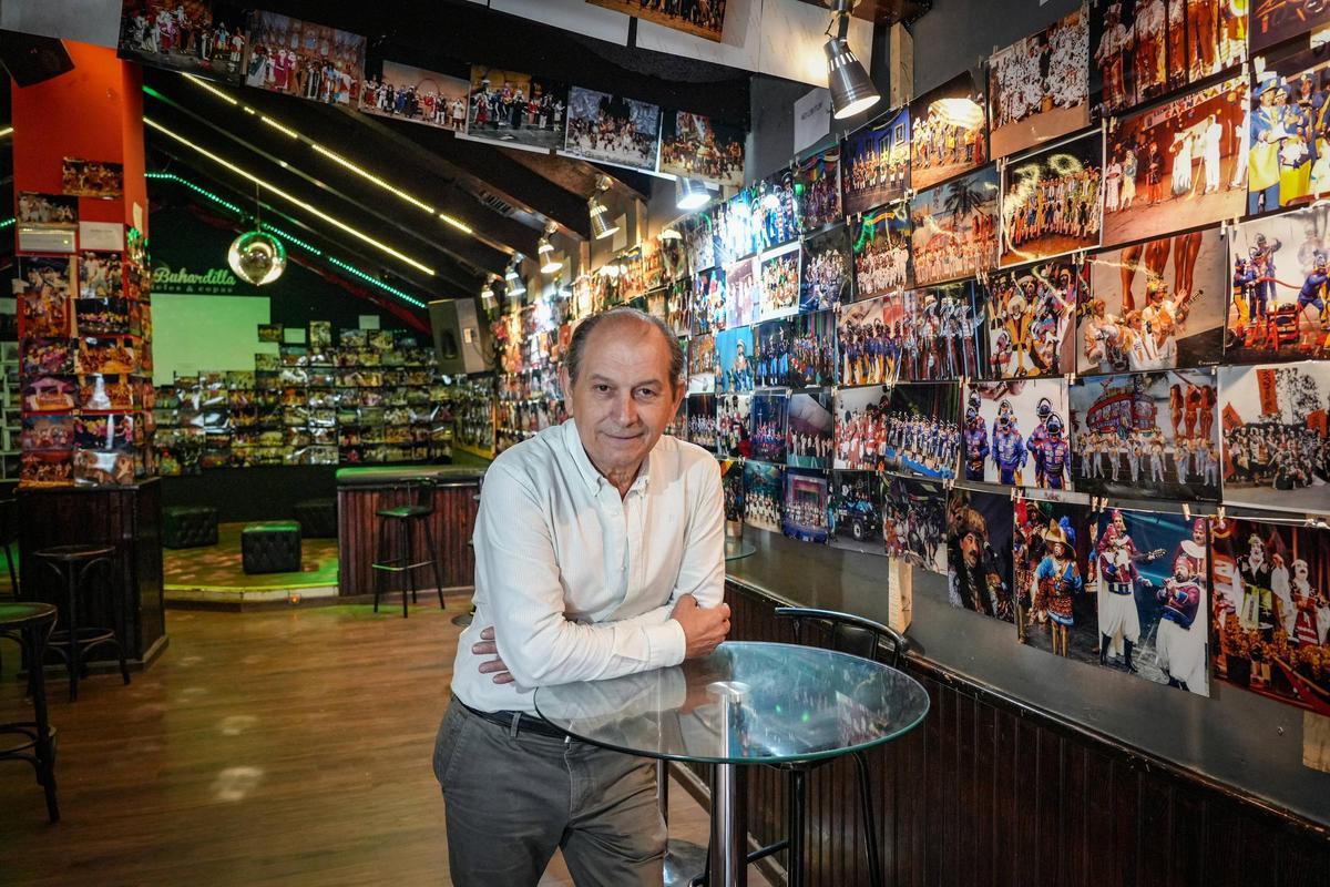 Pedro Noriega, propietario de La Buhardilla, junto a la exposición de fotos.