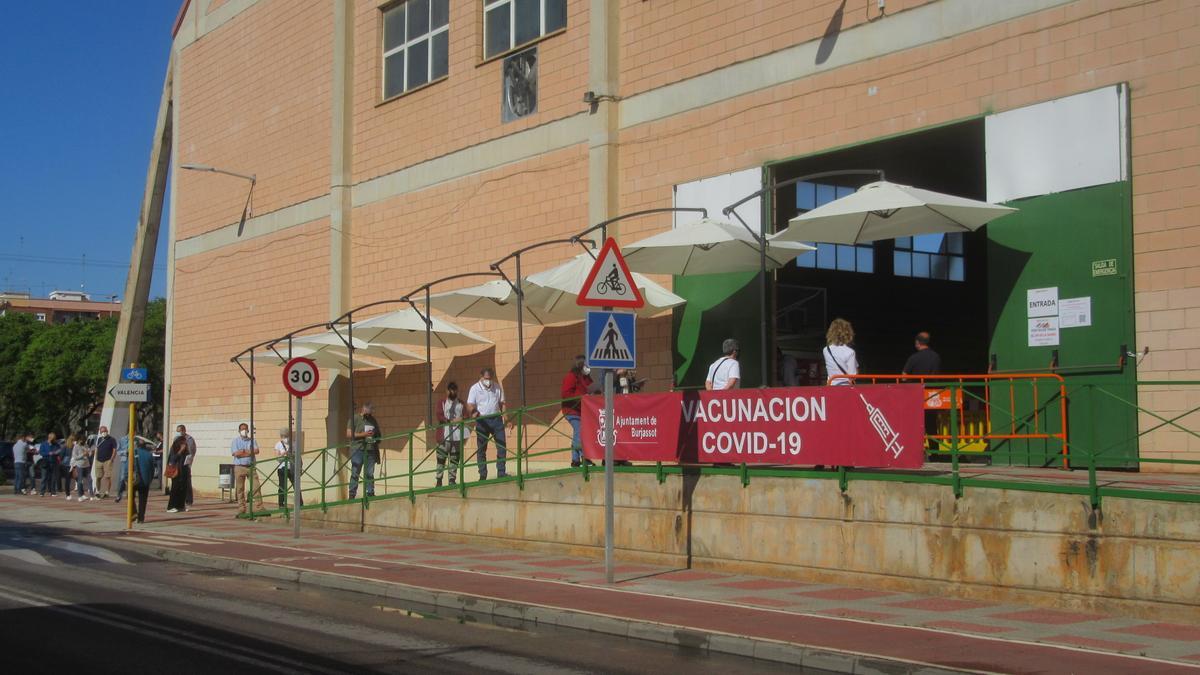 Personas citadas para la vacunación en Burjassot guardan la cola en el exterior del pabellón.