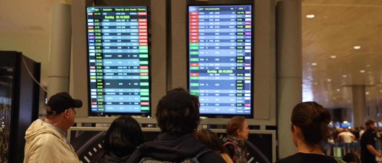 Pasajeros consultan el panel de salidas de vuelos en el aeropuerto de Ben Gurión, en Tel Aviv.