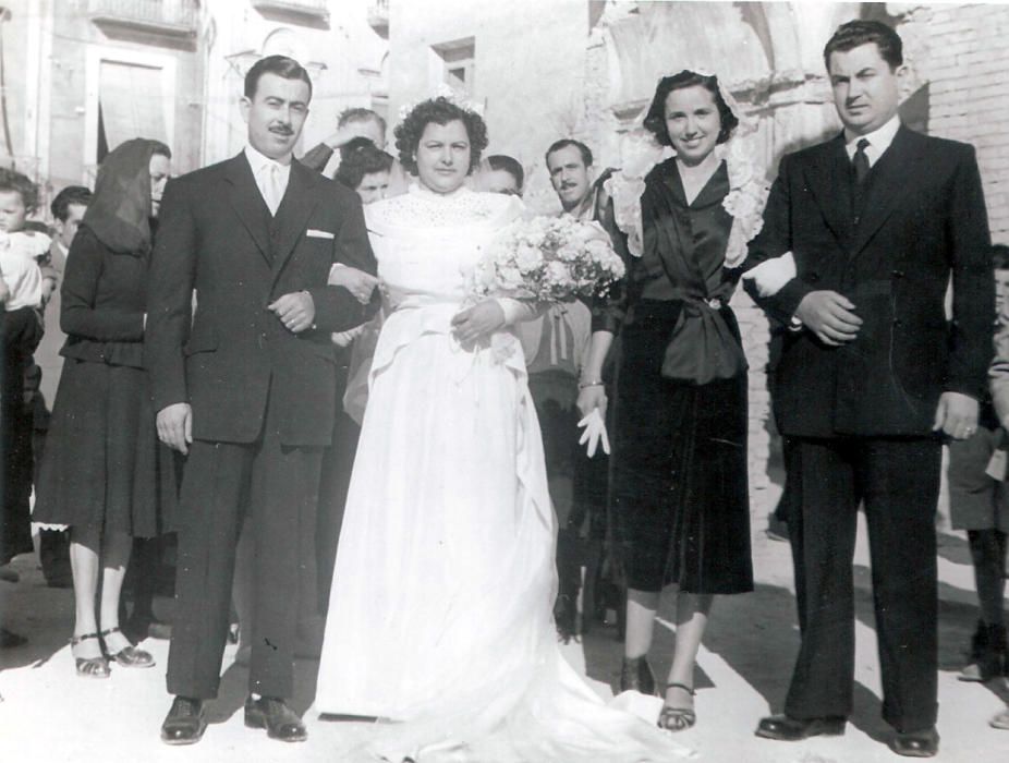 BLANC SOBRE NEGRE (Noces de dol). Antonia Penalva Asensi i José Sempere Fuentes, el 29 de març de 1951, amb Carmen Penalva Asensi i José López, com a padrins. En qualsevol casament destaca el blanc de la núvia sobre els colors de la resta de personatges que compleixen el ritu i sorprén el blanc en aquells casaments de després de la guerra, quan el dol ho cobria tot, fins i tot el vestit de les xiques que arribaven a l'altar. El negre envolta aquesta núvia: el negre de la germana major, fadrina, i aquí també padrina perquè el pare morí malalt dels pulmons, el negre sempre elegant dels homes, enlluernador en el cas del cunyat del marit que assumeix el paper de cap de la família, el negre dels convidats i dels curiosos, enmarcats entre les runes d'una esglèsia, la de Sant Salvador d'Elx. Així, malgrat vestir-se de blanc, és impossible que una ombra no cobrisca la cara de la núvia, que no l'abandonara mai encara que conegué el goig amb els seus descendents, als quals acaben per fer comprendre l'abast d'una vida aquells arrels negres.