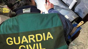 Imagen de archivo de un guardia civil examinando unos cilindros de una máquina donde se descubrió un alijo de cocaína.