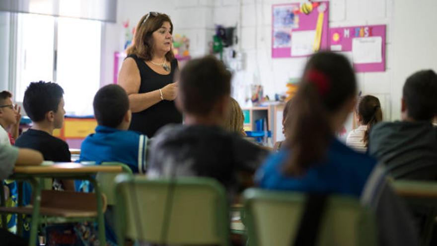 Un grupo de alumnos permanece atento a la explicación del docente.