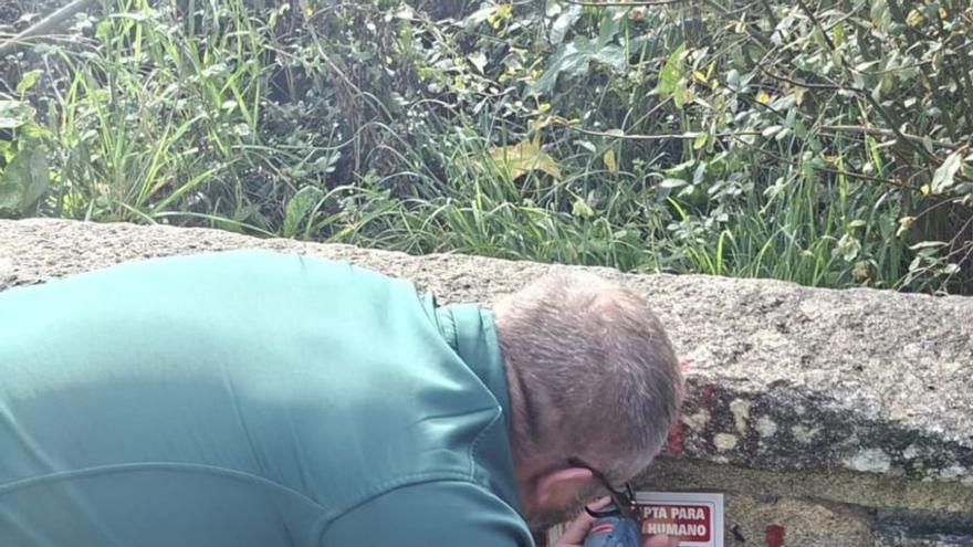 Un técnico colocando un cartel en una de las fuentes. |  T.Hermida