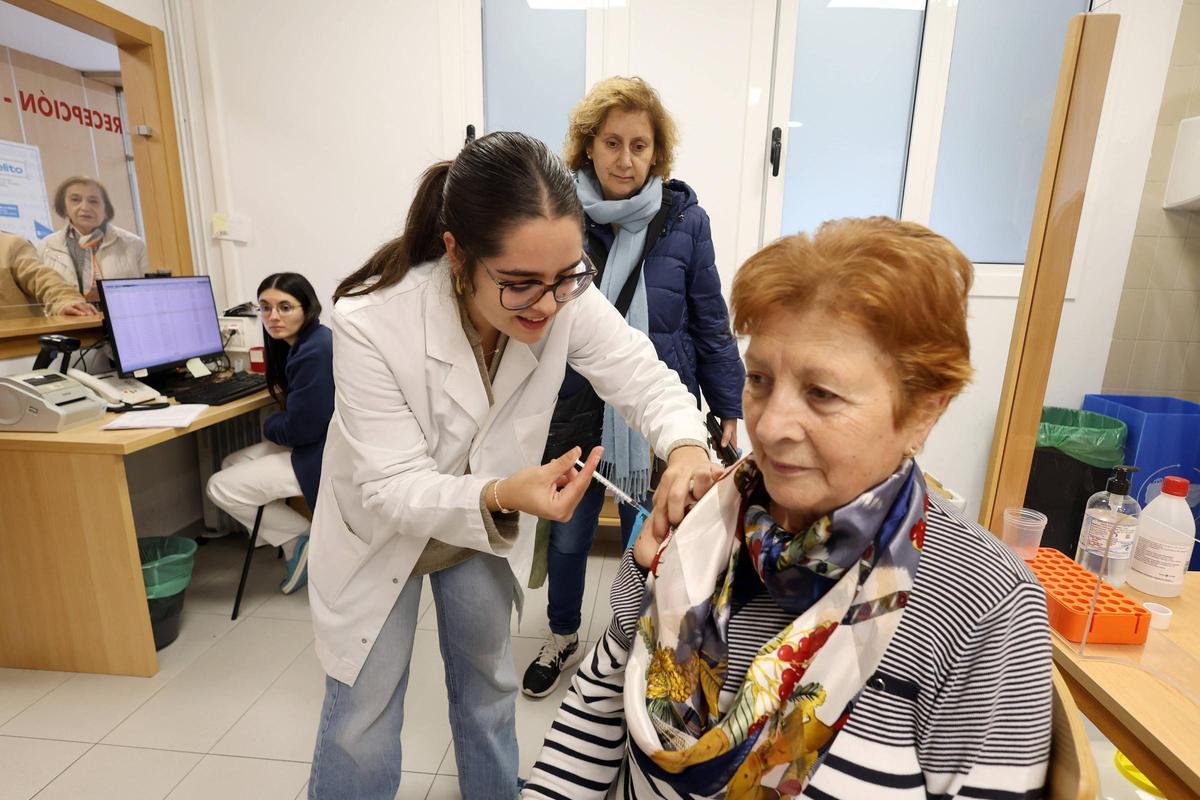 Una mujer recibe la vacuna de la gripe al inicio de la campaña en el centro de salud Virxe Peregrina.