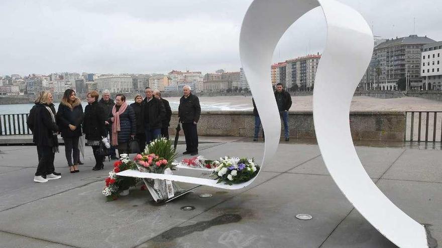 Familiares de los policías fallecidos y ediles del PP, ayer, en la ofrenda en el monumento del Orzán.