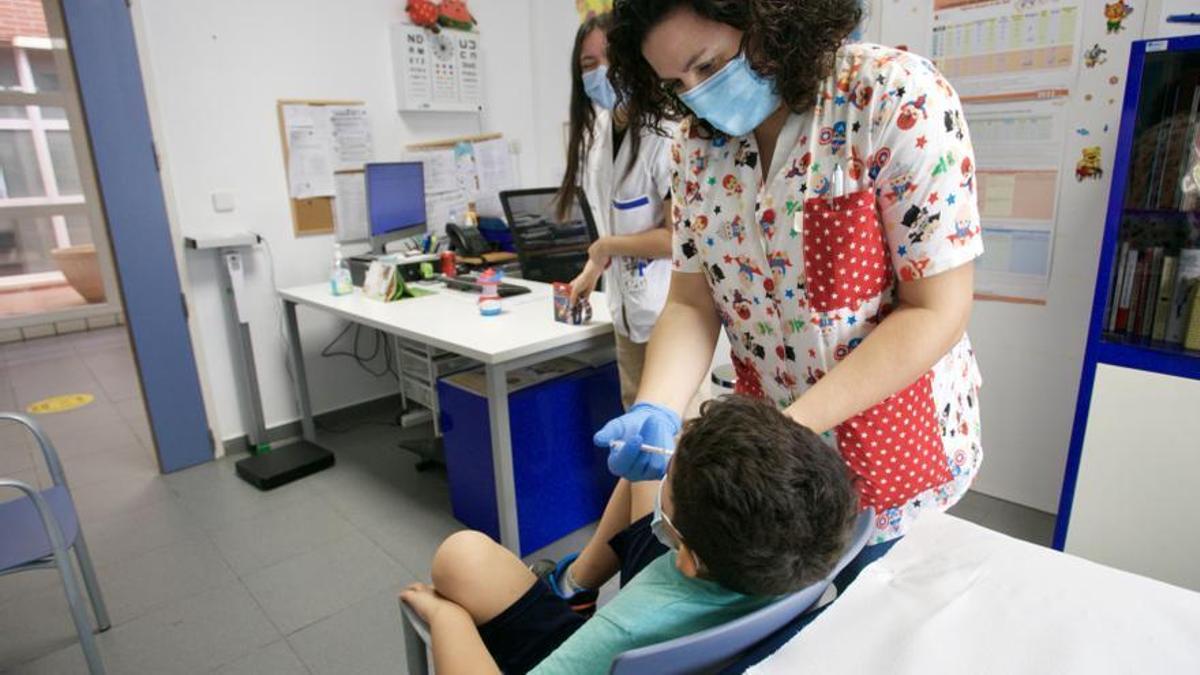 Enfermera vacuna a un niño con la dosis por vía nasal.