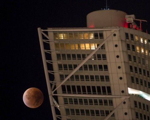 The supermoon appears behind the Turning Torso building during a total lunar eclipse in Malmo, south of Sweden