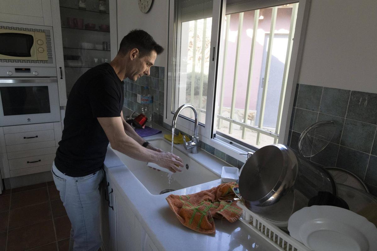 Imagen de archivo de un vecino del Carraixet lavando los platos en su casa.