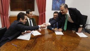 Los secretarios generales del PP, Teodoro García Egea, y de Vox, Francisco Javier Ortega Smith, estrechan las manos delante de los líderes andaluces del PP, Juanma Moreno y de Vox, Francisco Serrano, durante una reunión esta tarde en el Parlamento de Andalucía.