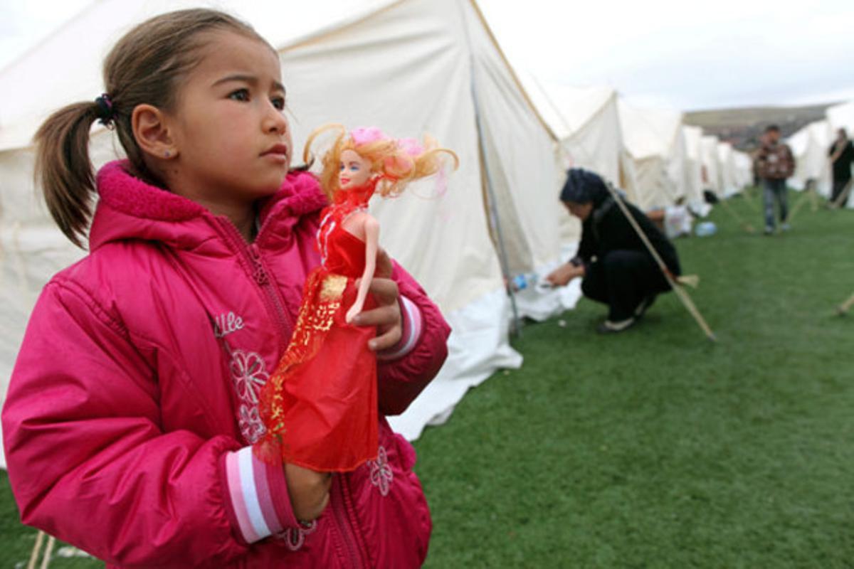 Una nena juga amb una nina en un campament per a damnificats després del terratrèmol que es va registrar aquest diumenge a Ercis (Turquia).