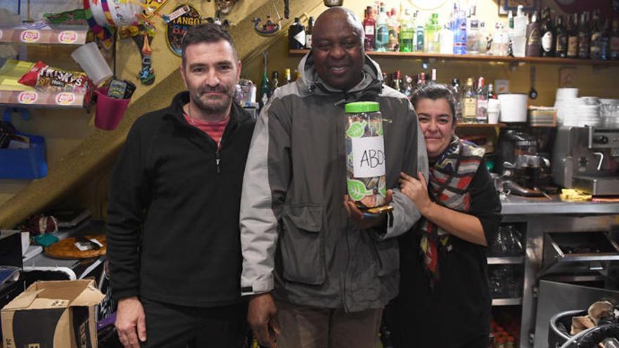 Abdou (c), con los responsables del bar Chaflán.