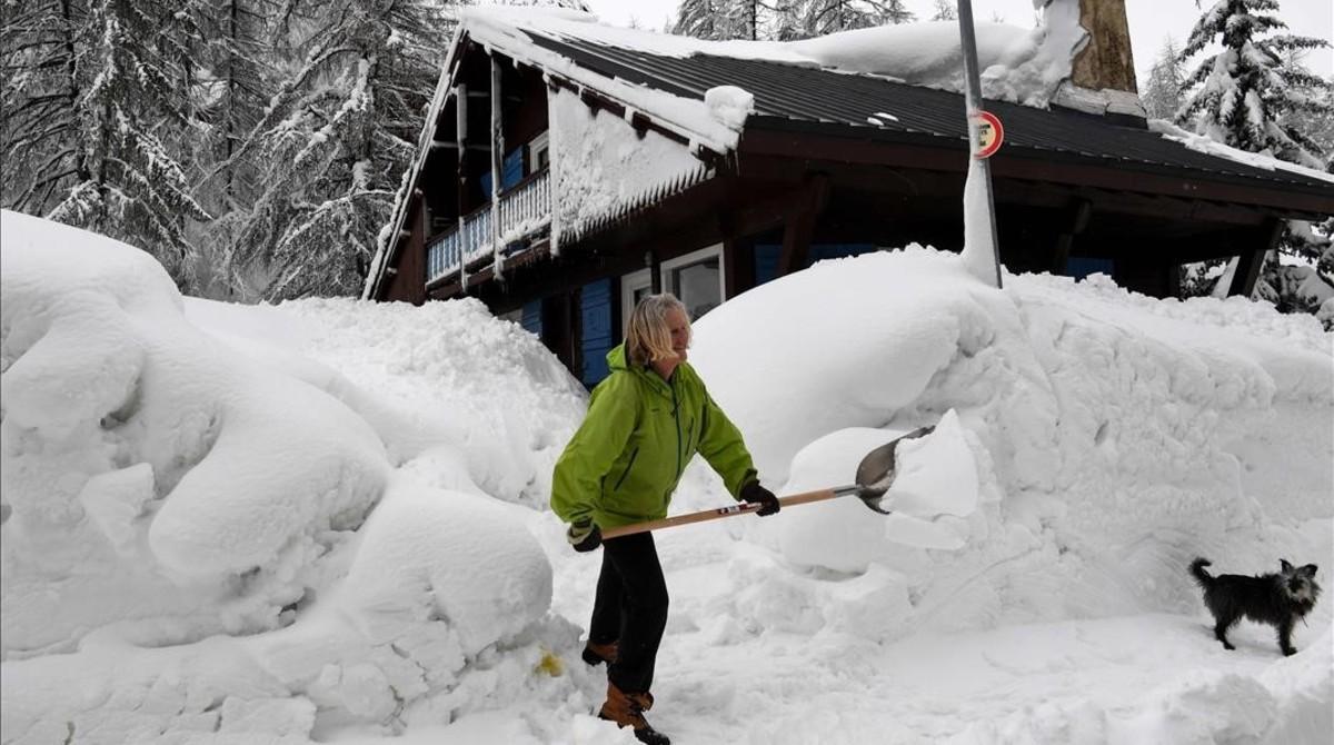 monmartinez41536575 a woman shovels snow in the village of val d isere  as the p180109163708