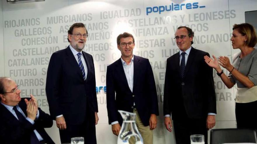 Herrera, primero por la izquierda, y Cospedal, a la derecha, aplauden a Feijóo y Alonso, ante Rajoy.