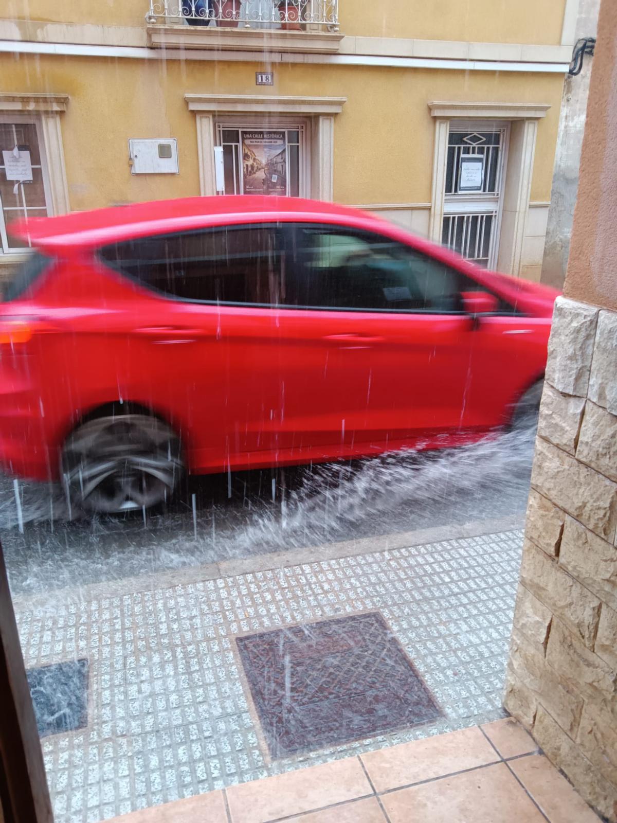 Un coche circula por la calle San José un día de lluvia