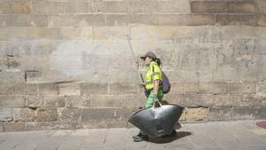 Una empleada del servicio de limpieza de la ciudad junto la Catedral de Barcelona, en pleno verano