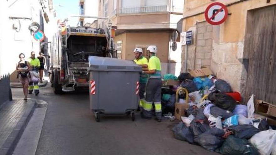 Un camión recogiendo basura de una calle