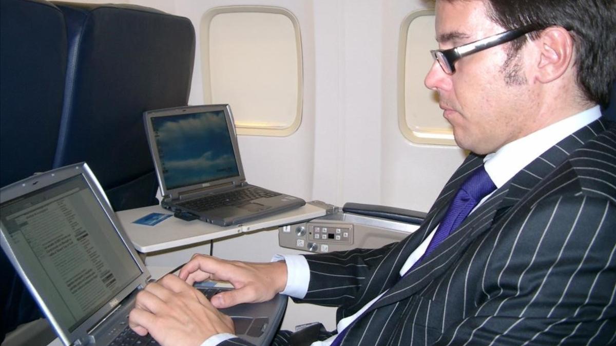Pasajeros usando el portátil en un vuelo.