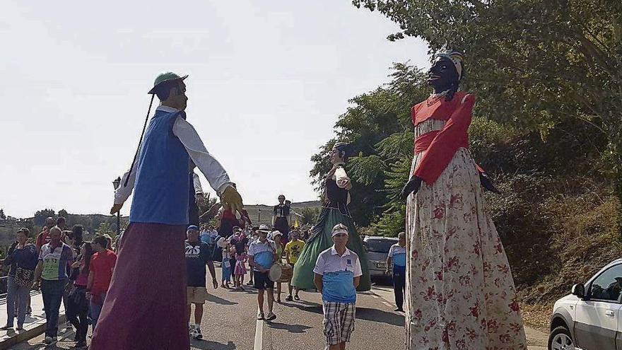 A la izquierda, vecinos y peñistas desfilan con los gigantes en las fiestas patronales de Las Victorias. A la derecha, un toro de fuego en su recorrido por las calles de la villa.