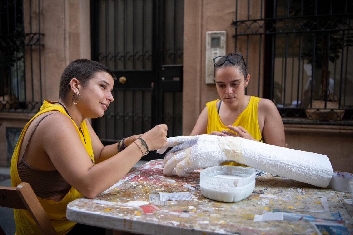 Dos vecinas la calle Tordera creando la textura de una mano gigante con papel higiénico, que será parte de los ‘guarniments’ de las fiestas mayores de Gràcia. Este año, 5 calles del barrio se han unido bajo la temática de ‘El Señor de los Anillos’. Barcelona, 4 de agosto de 2026. Foto: Belén González / EP