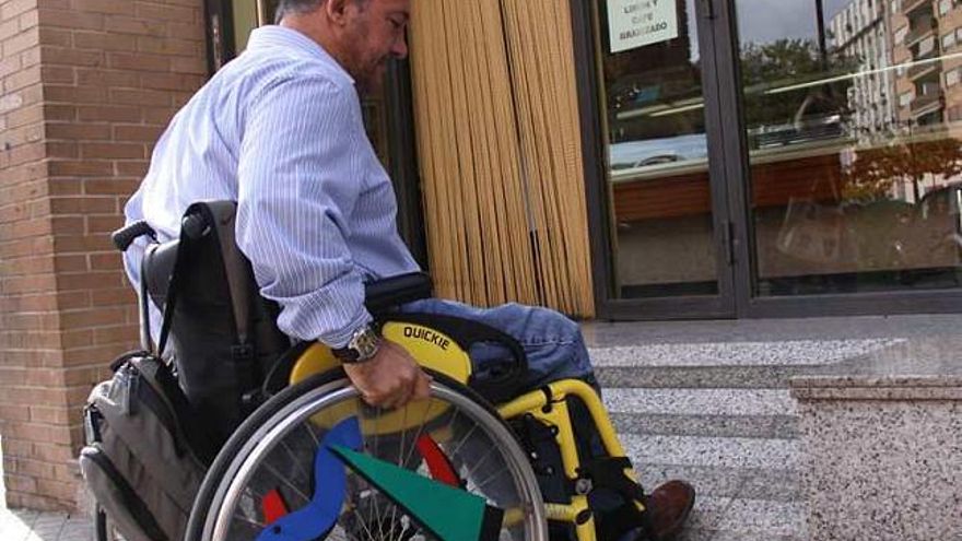 Francisco Canes ante un comercio con barreras arquitectónicas