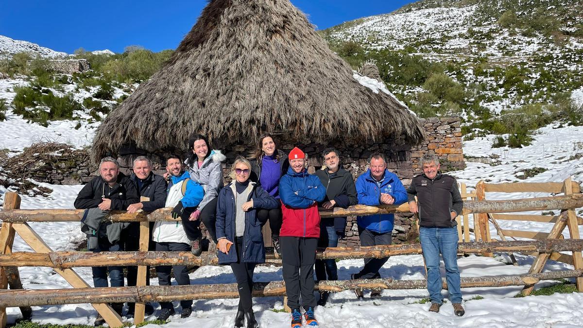 Turistas ingleses y españoles, posando este sábado, junto a un teito entre nieve en Saliencia (Somiedo).