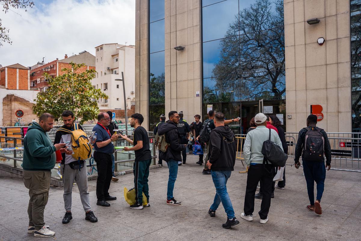Caos y una larga cola de personas que esperan regularizar su situación en España en la Oficina de Benestar Social i Família de Barcelona-Sants/Eixample.