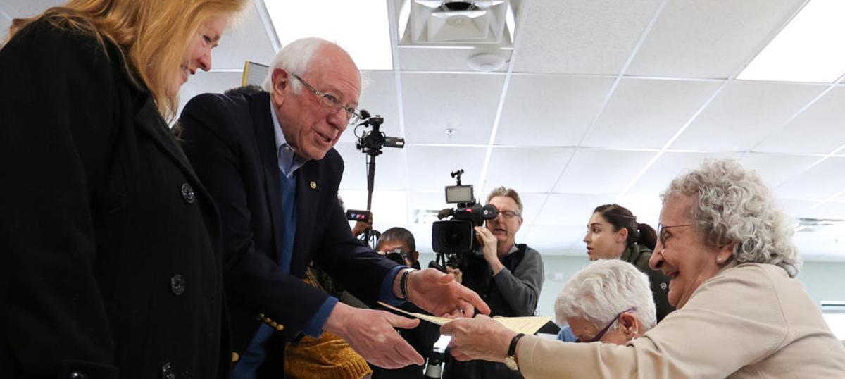 El candidato demócrata Bernie Sanders y su esposa Jane O'Meara Sanders reciben sus papeletas para votar en las primarias.
