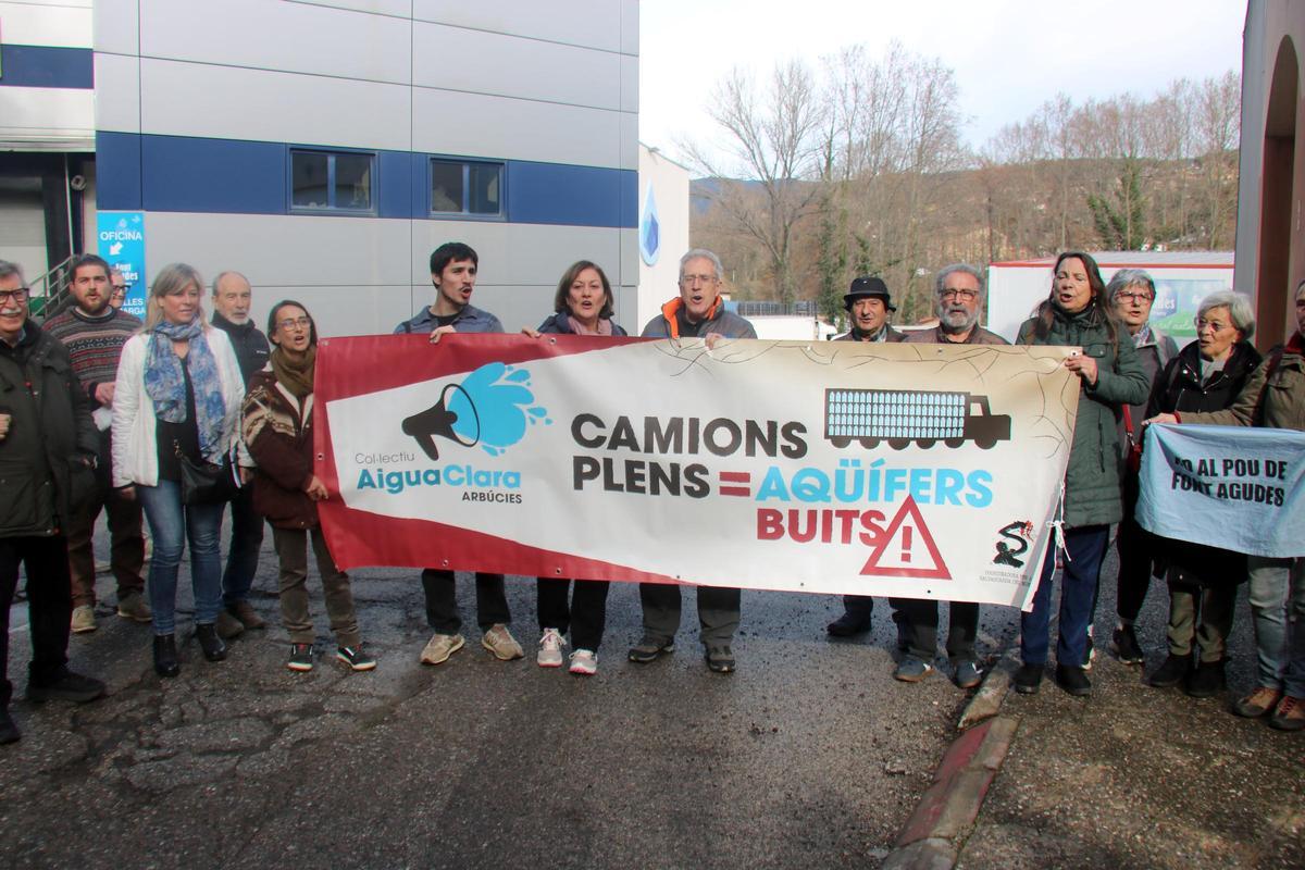 Representants dels ajuntaments que han subscrit la moció i entitats ecologistes protestant davant una planta embotelladora d'Arbúcies