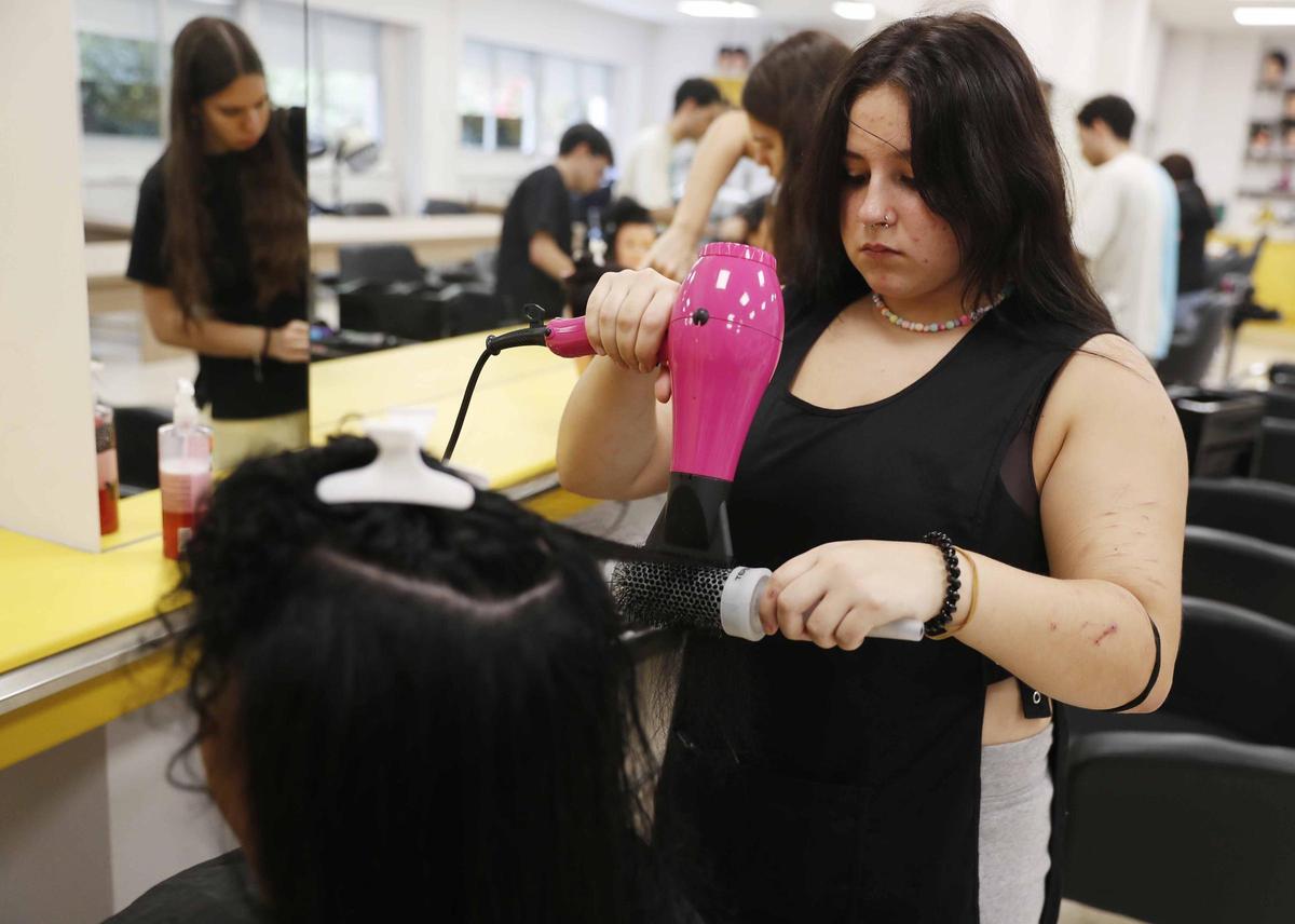 ALUMNOS DEL CICLO DE GRADO MEDIO DE PELUQUERIA Y COSMETICA CAPILAR DEL IES DE TEIS, EN VIGO, EN UNO DE SUS TALLERES, EN LOS QUE TIENEN QUE USAR APARATOS DE ALTO CONSUMO COMO LOS SECADORES PESE A LA SUBIDA DEL PRECIO DE LA ELECTRICIDAD.