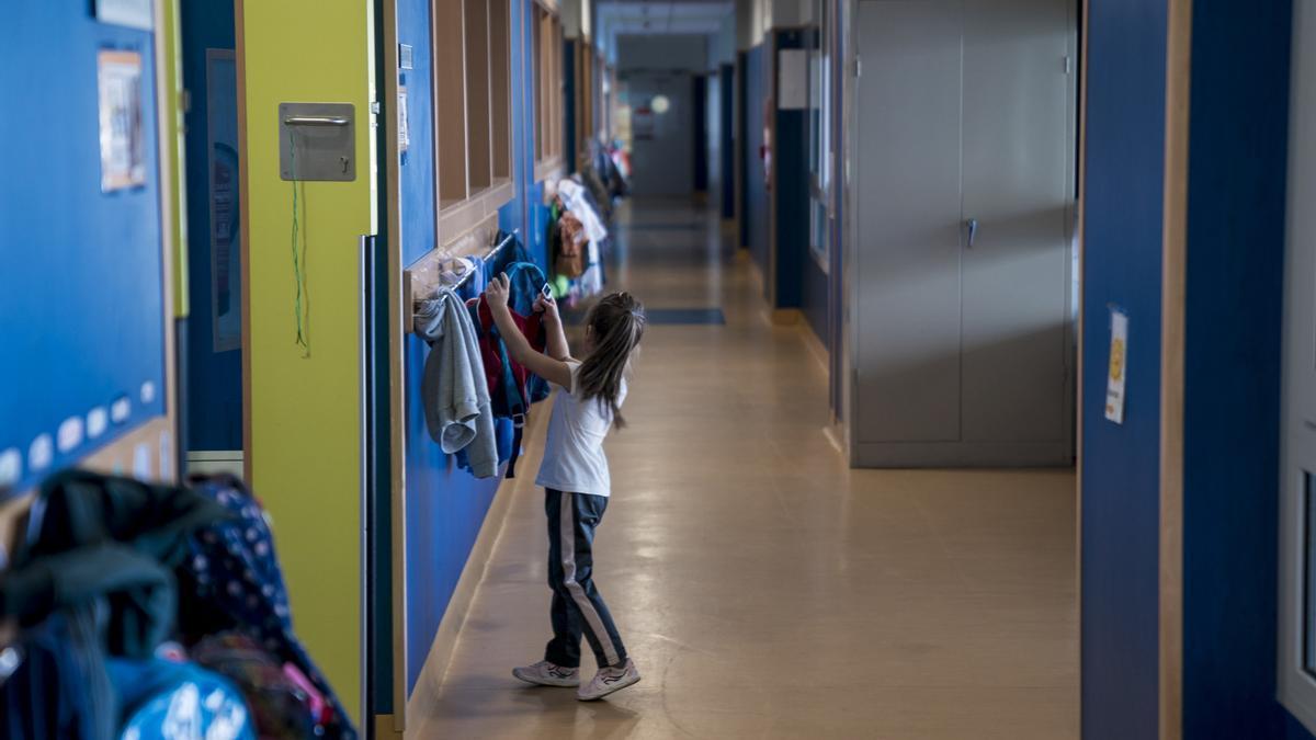 Una niña cuelga su mochila en un colegio (archivo)