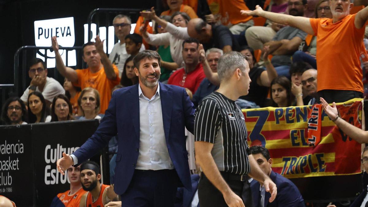 El entrenador del Valencia BC, Álex Mumbrú, sonríe al árbitro en una protesta