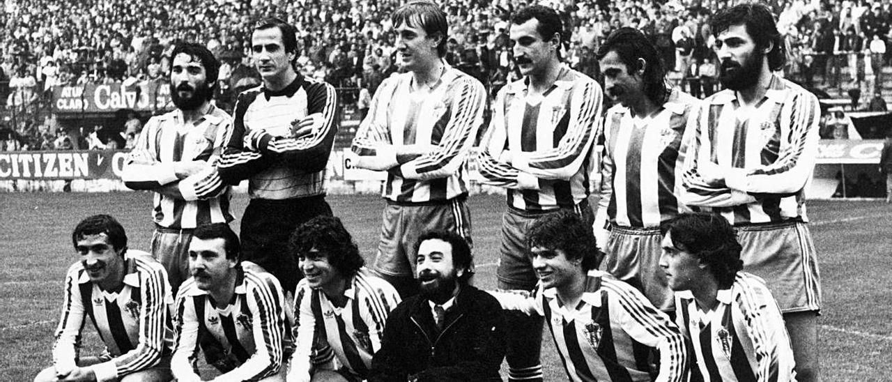 José Luis Garci, en el centro, posa en el césped de El Molinón con la plantilla del Sporting de Gijón en 1983, con el “Óscar” de “Volver a empezar”, delante.