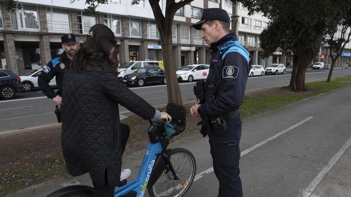 Un agente de la Policía Local informa de las normas de uso de BiciCoruña.