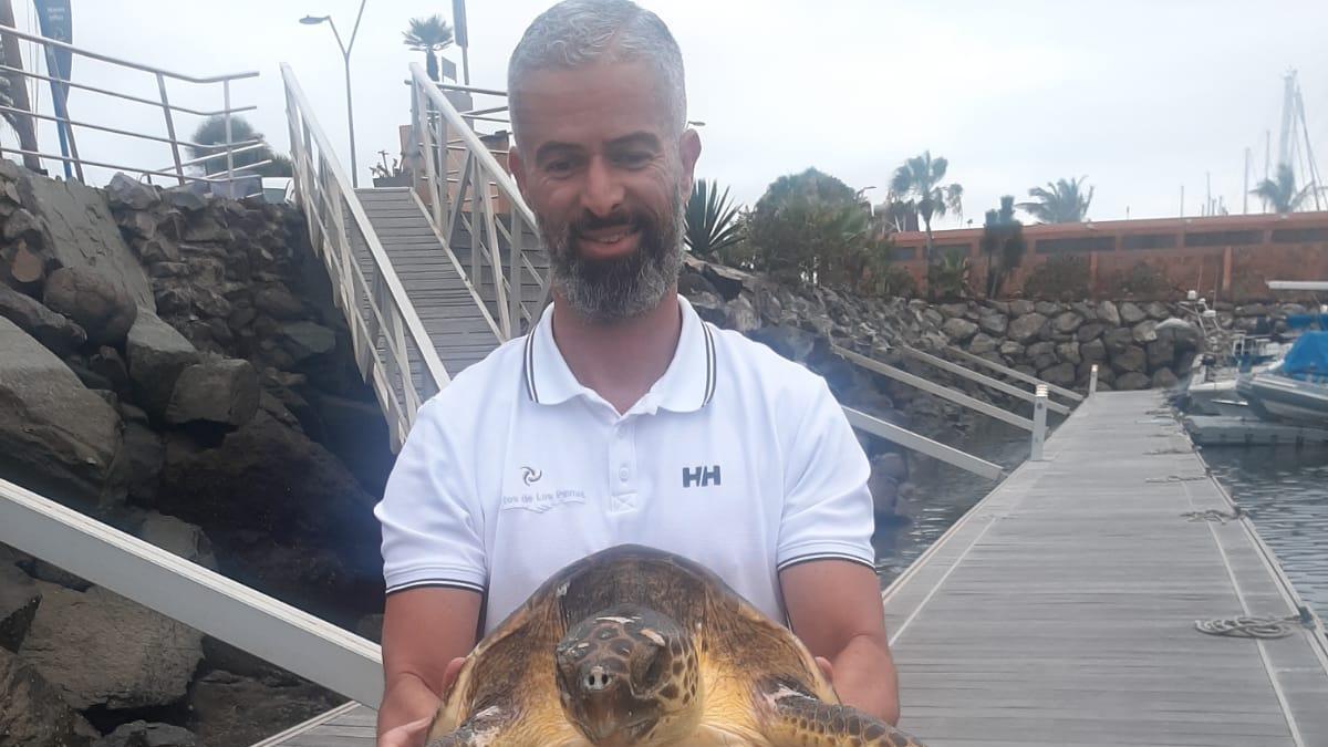 Cristo García con la tortuga rescatada en el Muelle Deportivo.