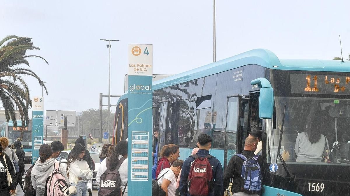 Un grupo de personas hace cola para entrar en una guagua.