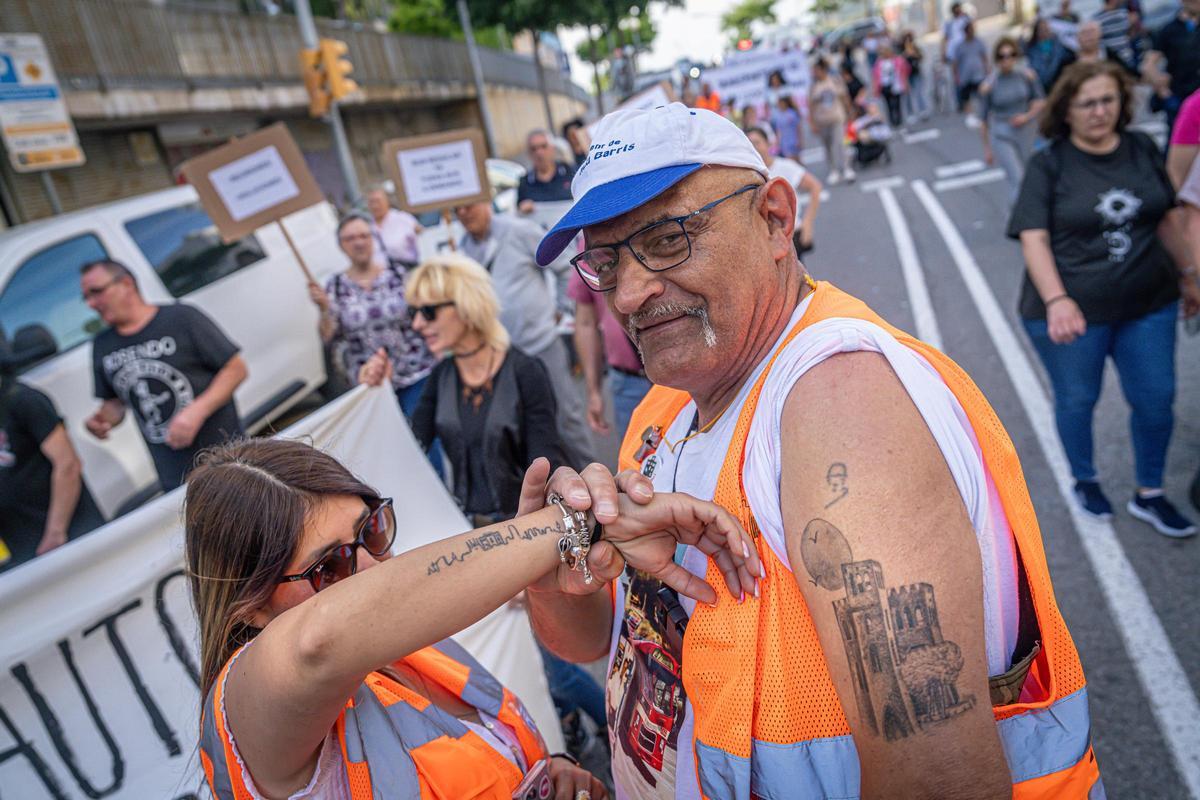 Valeria Ortiz y José Manuel Romero, 'Rope', luciendo tatuajes de Torre Baró en la manifestación para pedir una línea regular de bus, en Barcelona.
