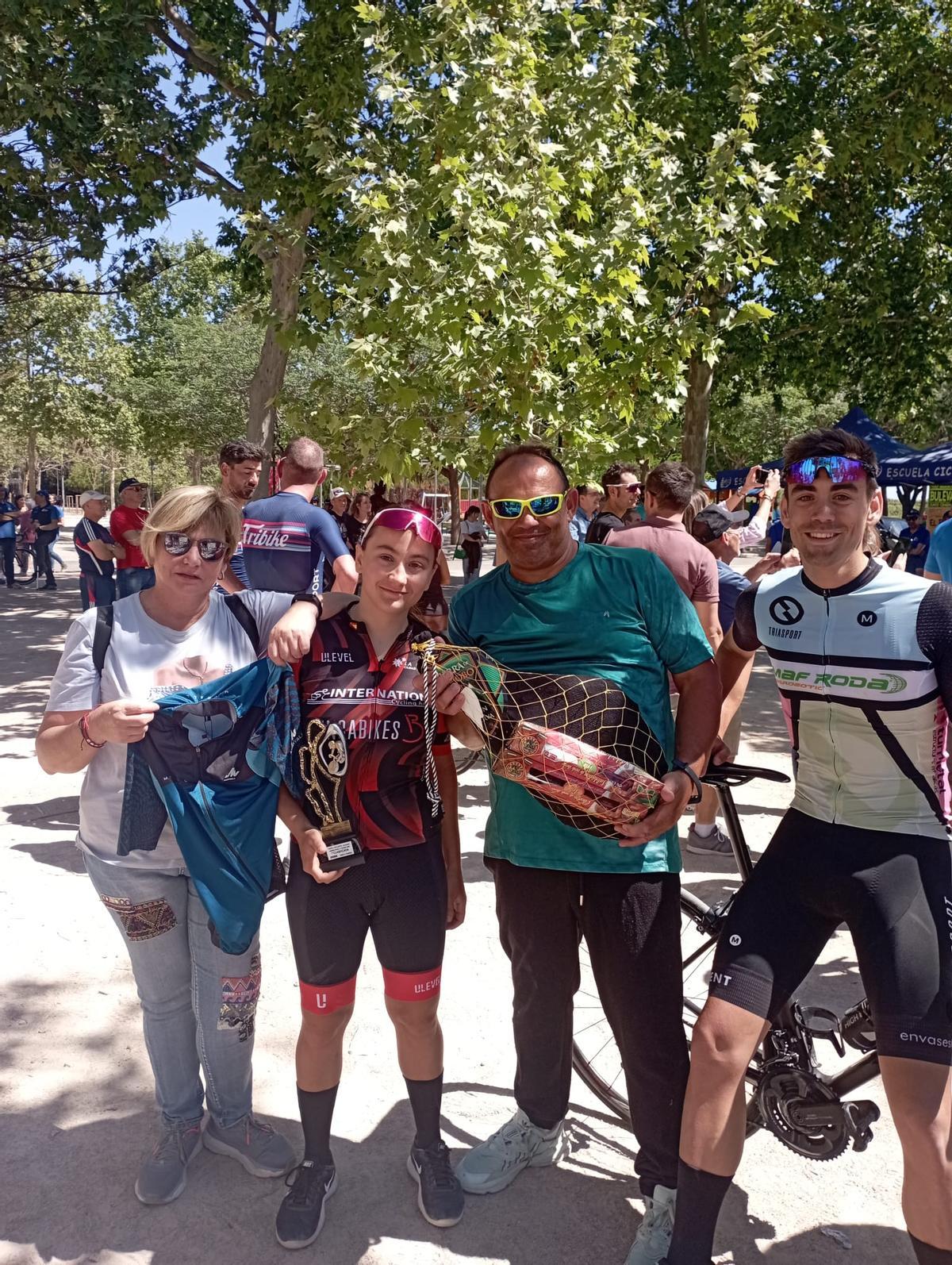 Lidia Llácer Gabarrón con el jamón del premio junto a sus padres y su hermano Joan