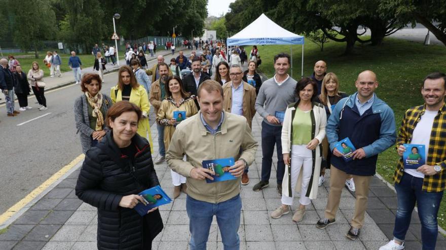 Carmen Moriyón y Adrián Pumares, delante de sus equipos, en el reparto de propaganda electoral en el rastro gijonés. | Marcos León