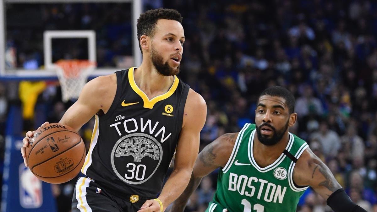 Stephen Curry bota el balón ante Kyrie Irving.