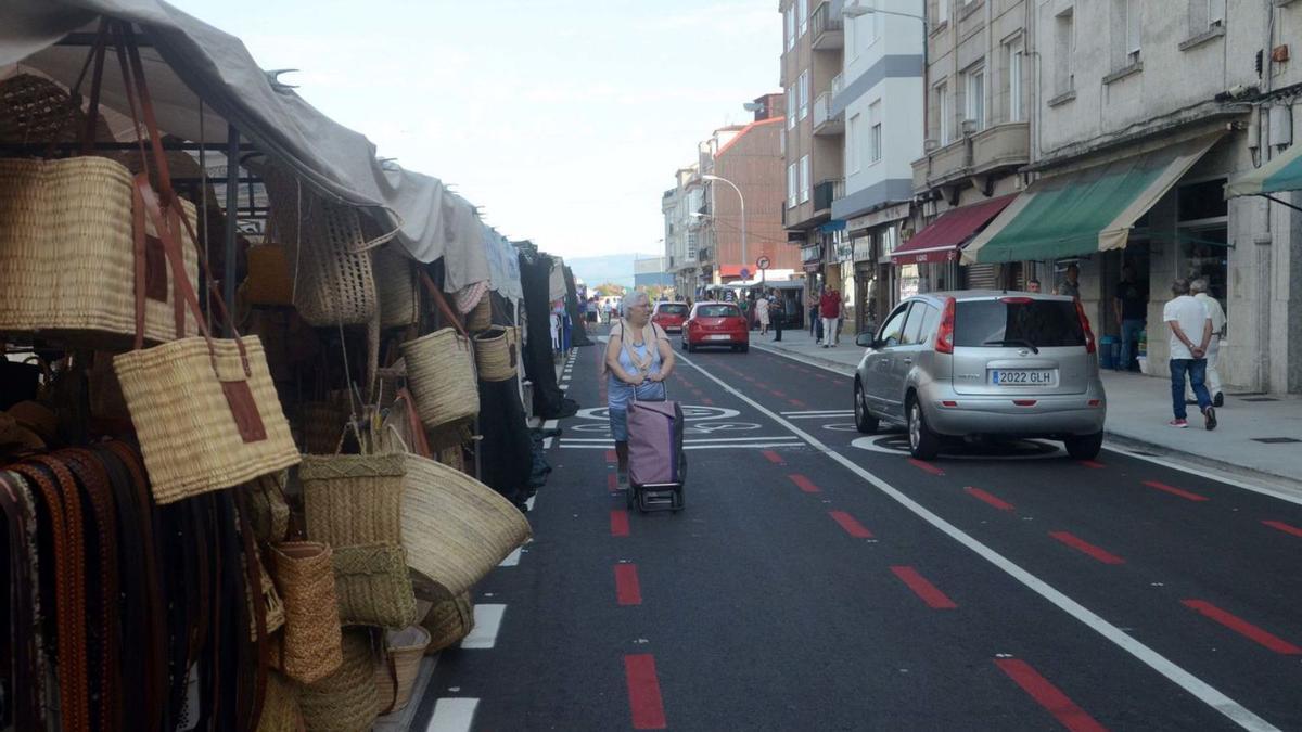 Una mujer camina por la calzada, mientras por el carril contrario circulan vehículos.   | // NOÉ PARGA