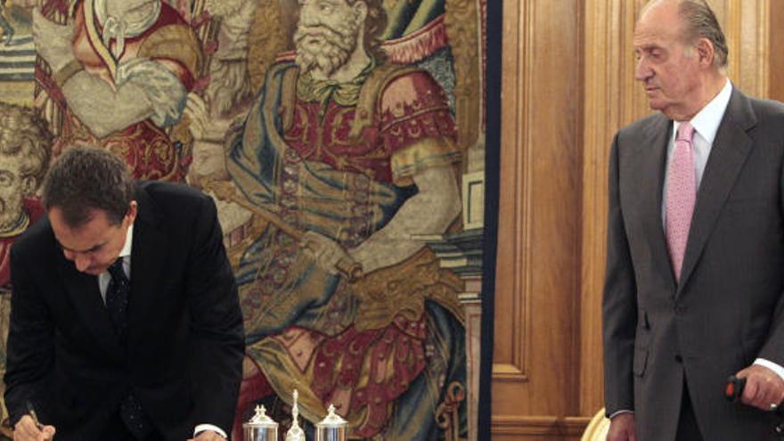 Zapatero firma la reforma en presencia de Don Juan Carlos.