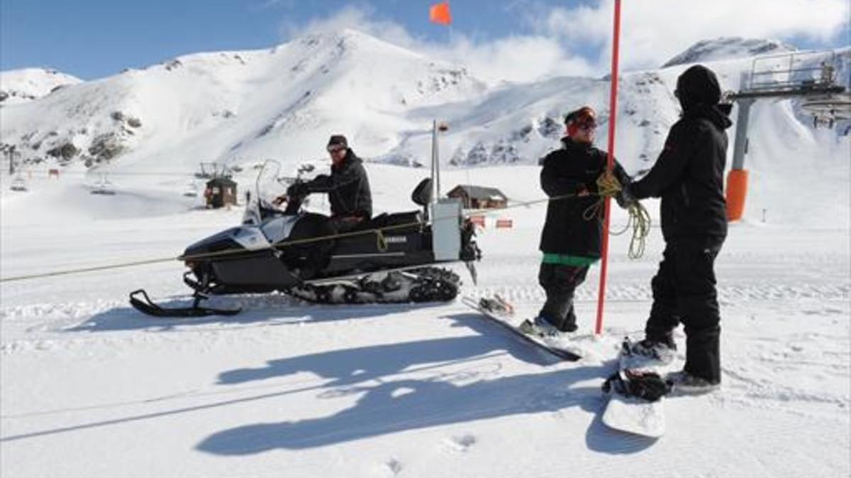 Técnicos de la estación de Boí Taüll acondicionan las pistas de esquí, ayer.