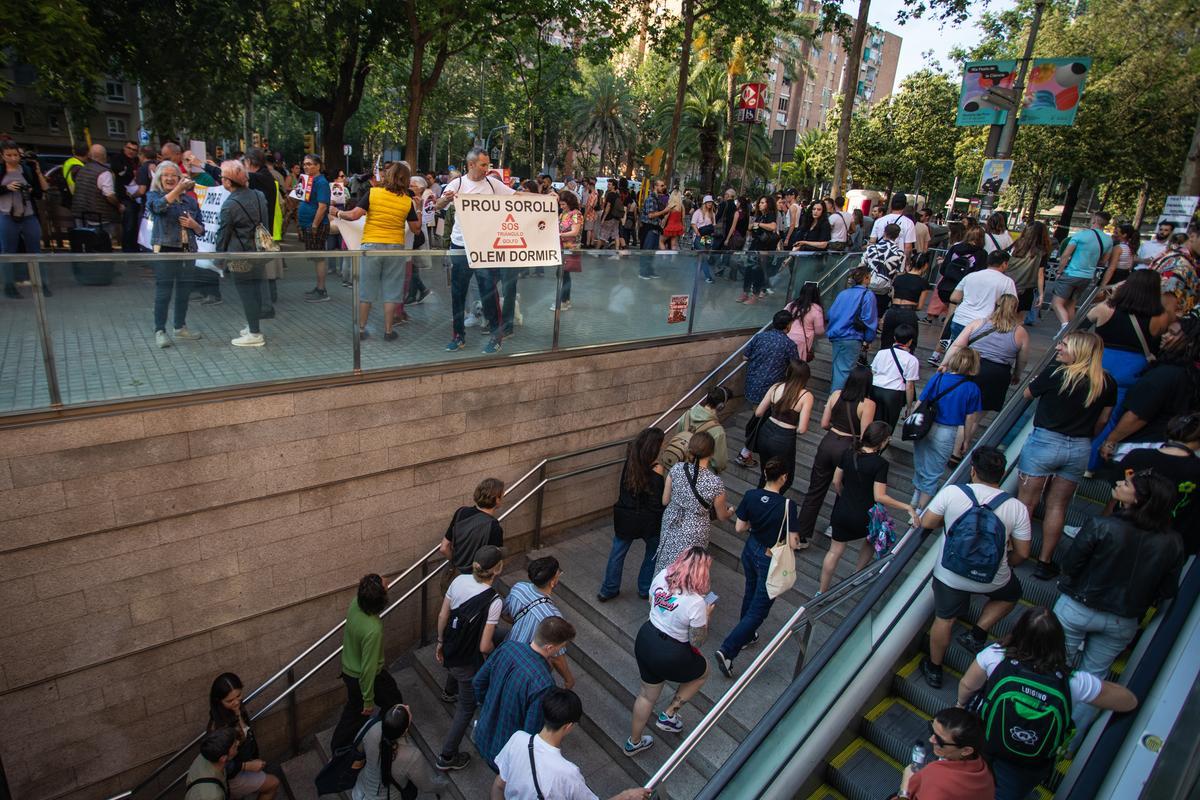 Asistentes al Primavera Sound salen por la boca del metro durante la concentración contra el ruido, en Barcelona.