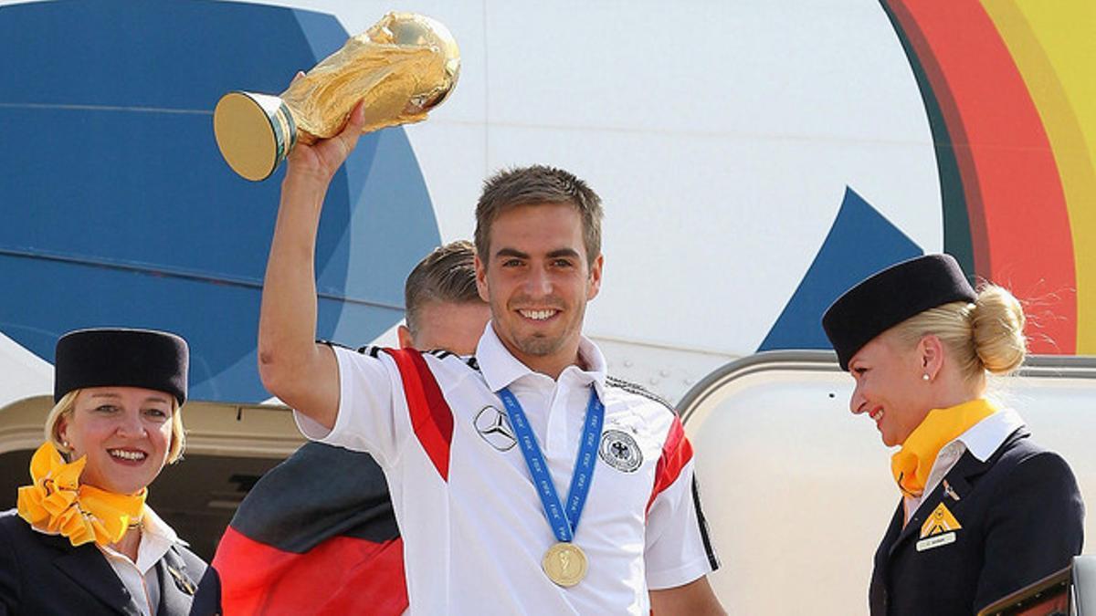 Lahm muestra la Copa del Mundo desde la escalerilla del avión a la llegada de la selección alemana a Berlín.