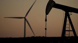 Una estación de bombeo de petróleo junto a un molino de viento 