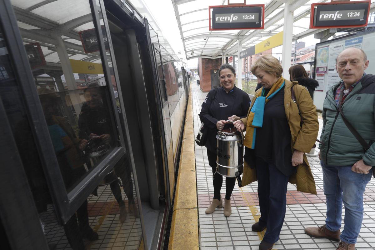Mariví Monteserín y Agustín Medina suben al tren en Avilés con la cocinera Pilar Meana para llevar la olla ferroviaria a Candás